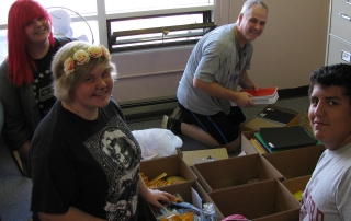 Volunteers with boxes of donated school supplies
